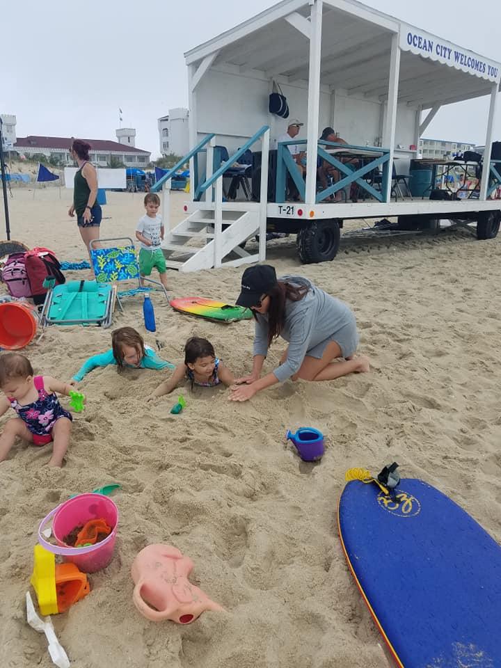 mom playing with kids on the beach