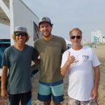 three surfer dudes on beach