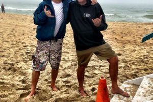 two guys standing on beach
