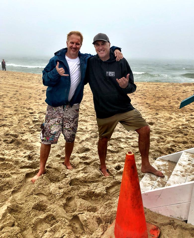 two guys standing on beach